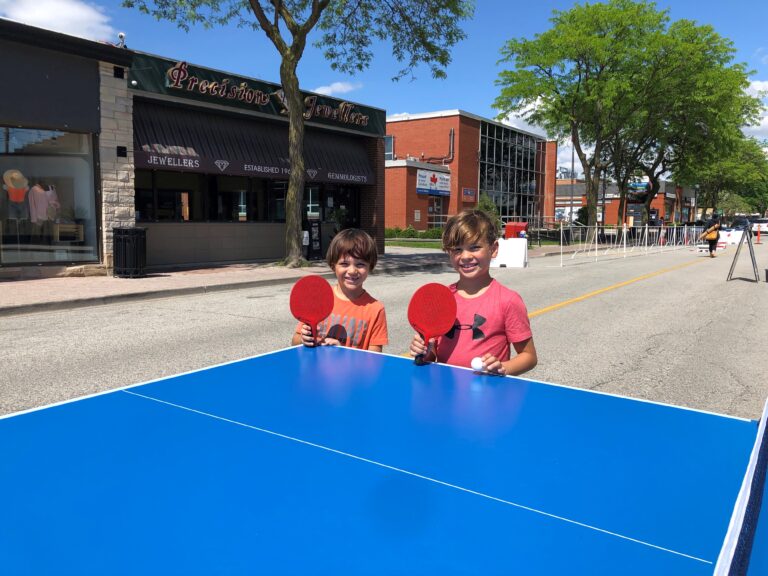<p>Two boys next to ping pong table</p>