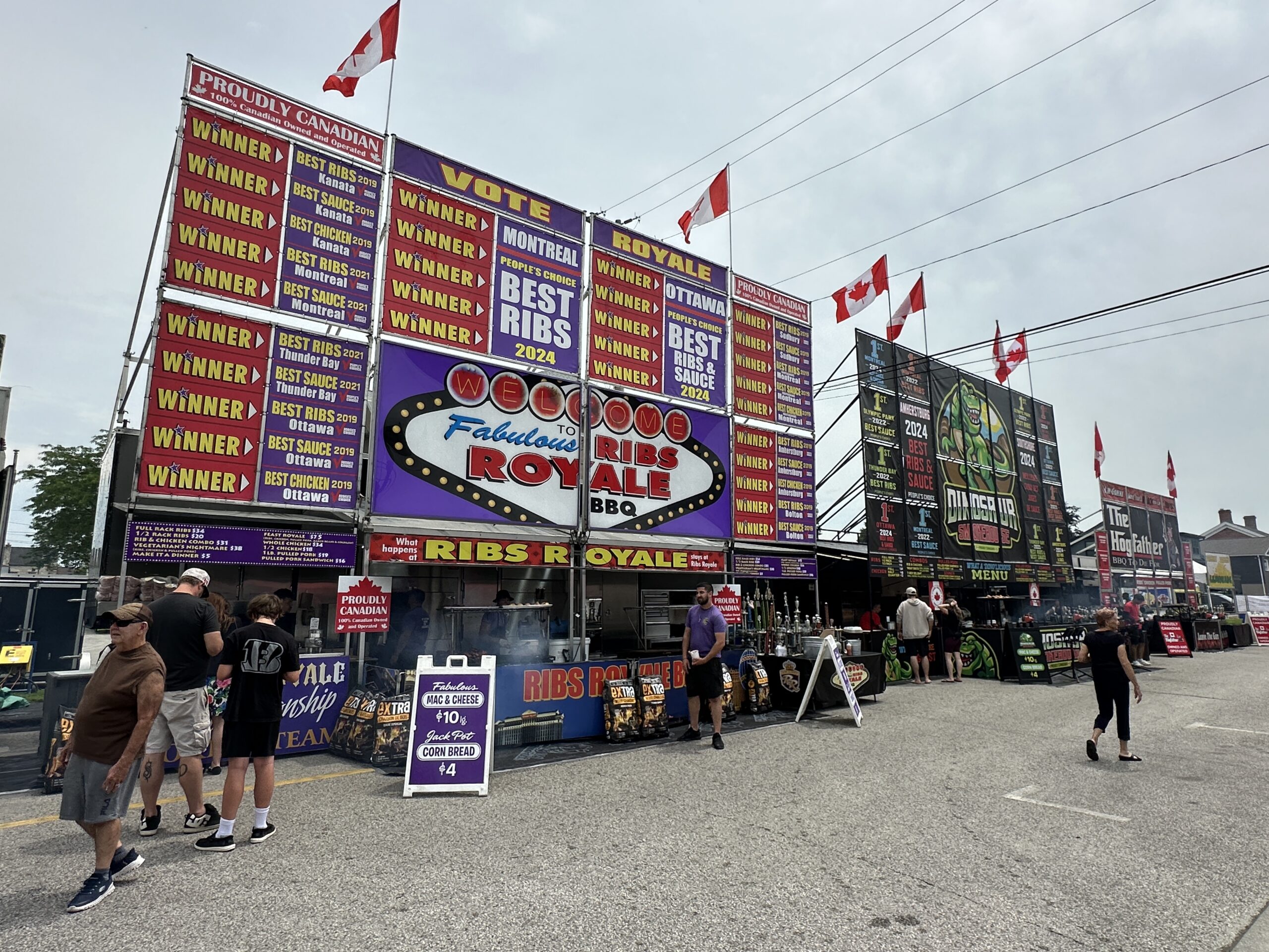 Amherstburg Ribfest food vendors lined up along Ramsay Street. Large signs featuring menus and awards line the street