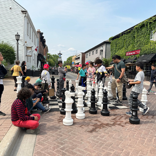 kids playing giant chess in the street