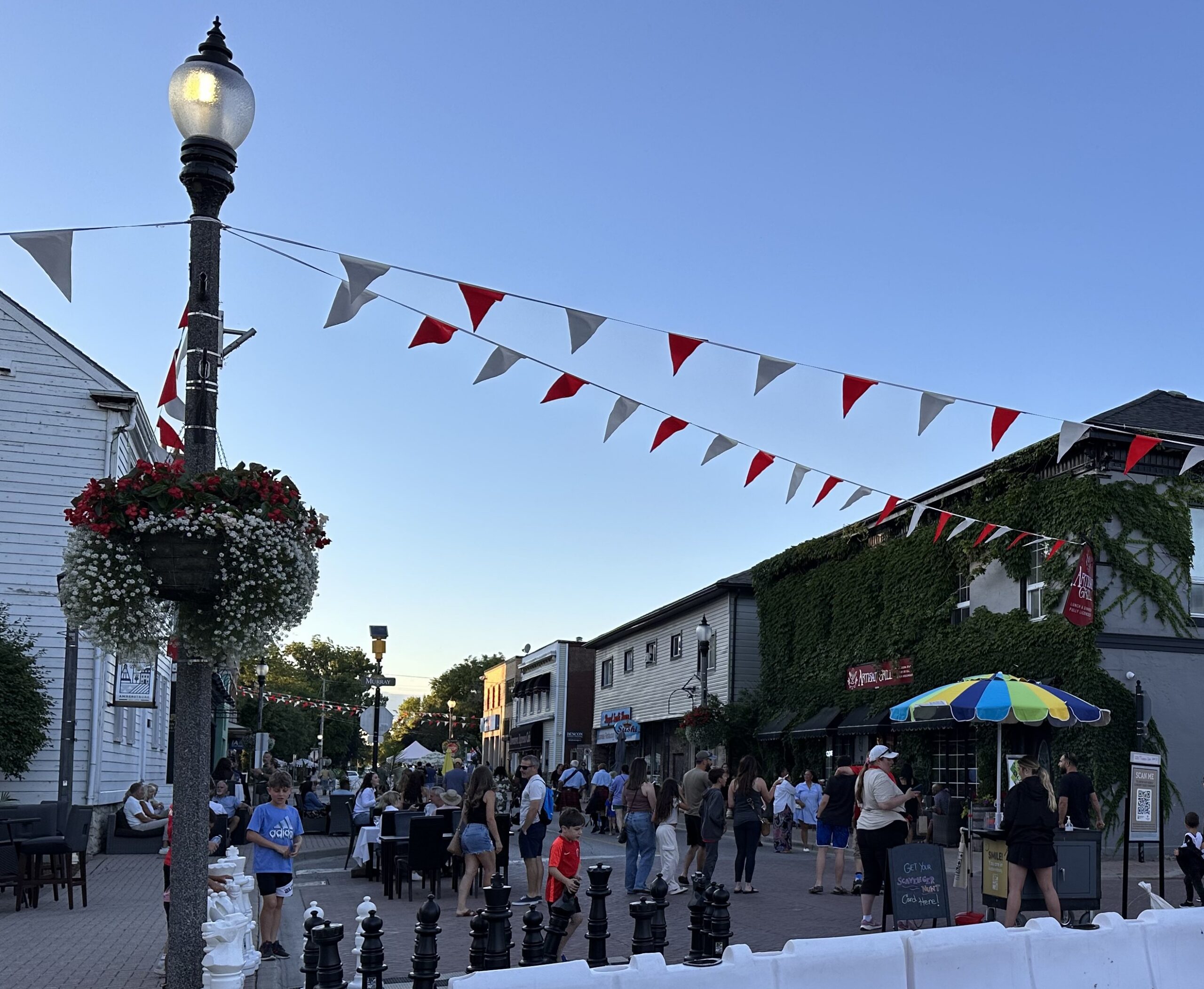 People on the Street at Open Air with decorations strung between buildings