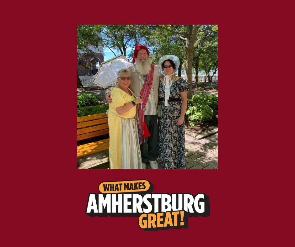 What Makes Amherstburg Great with three historic tour guides posing in front of a park bench