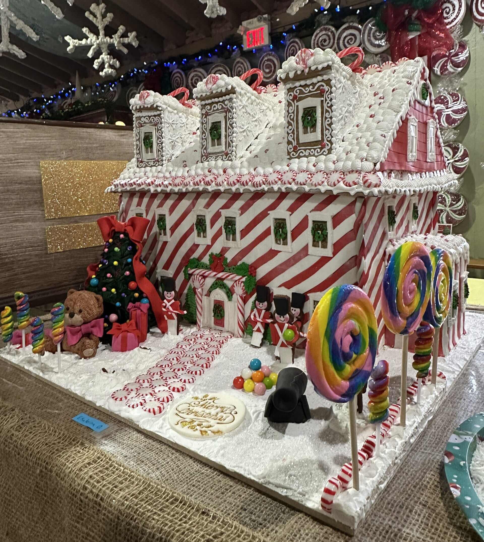 A large gingerbread house coloured in red and white like a candy cane.